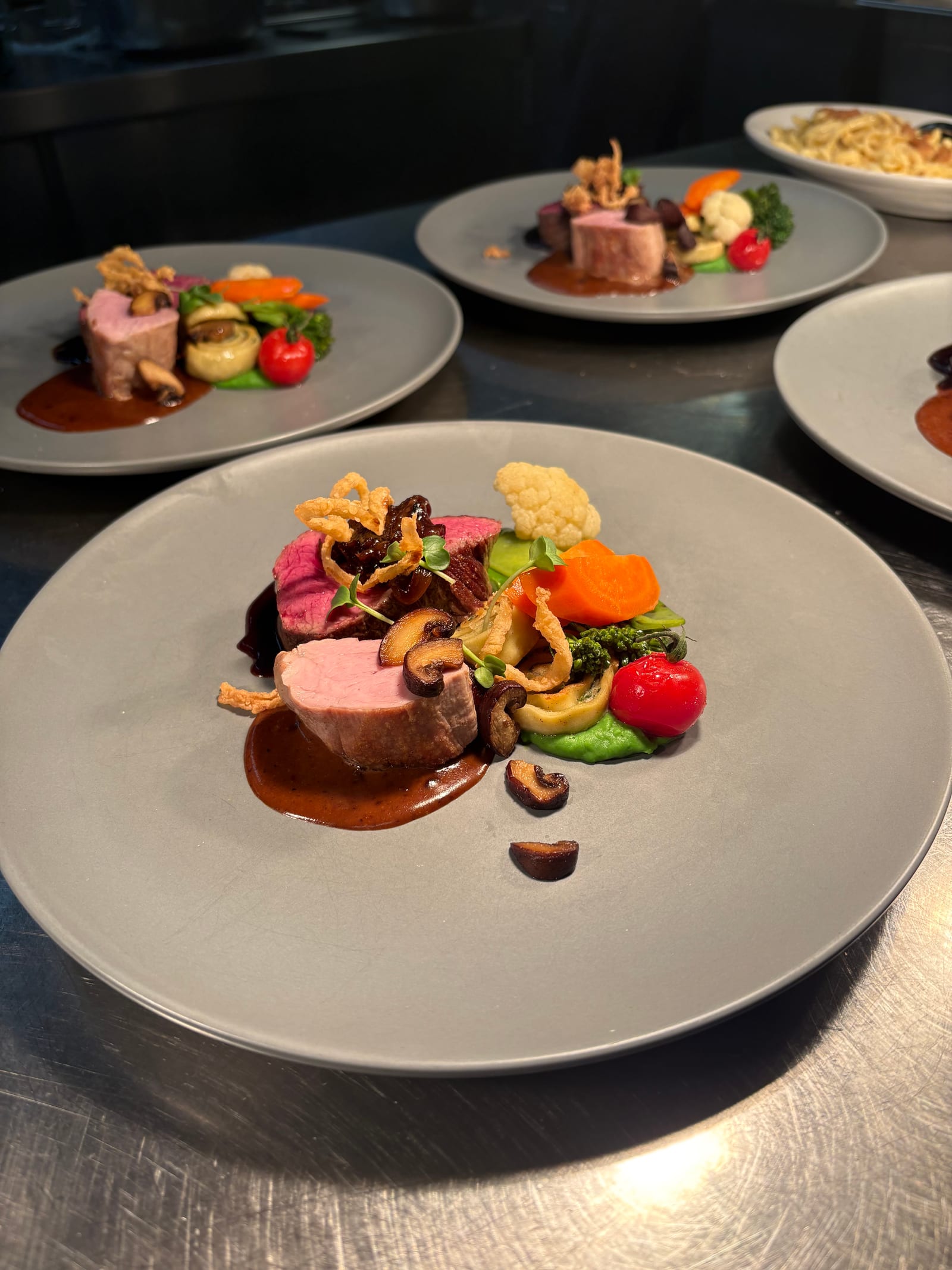 Rosa gebratenes Fleisch mit buntem Gemüse und Sauce