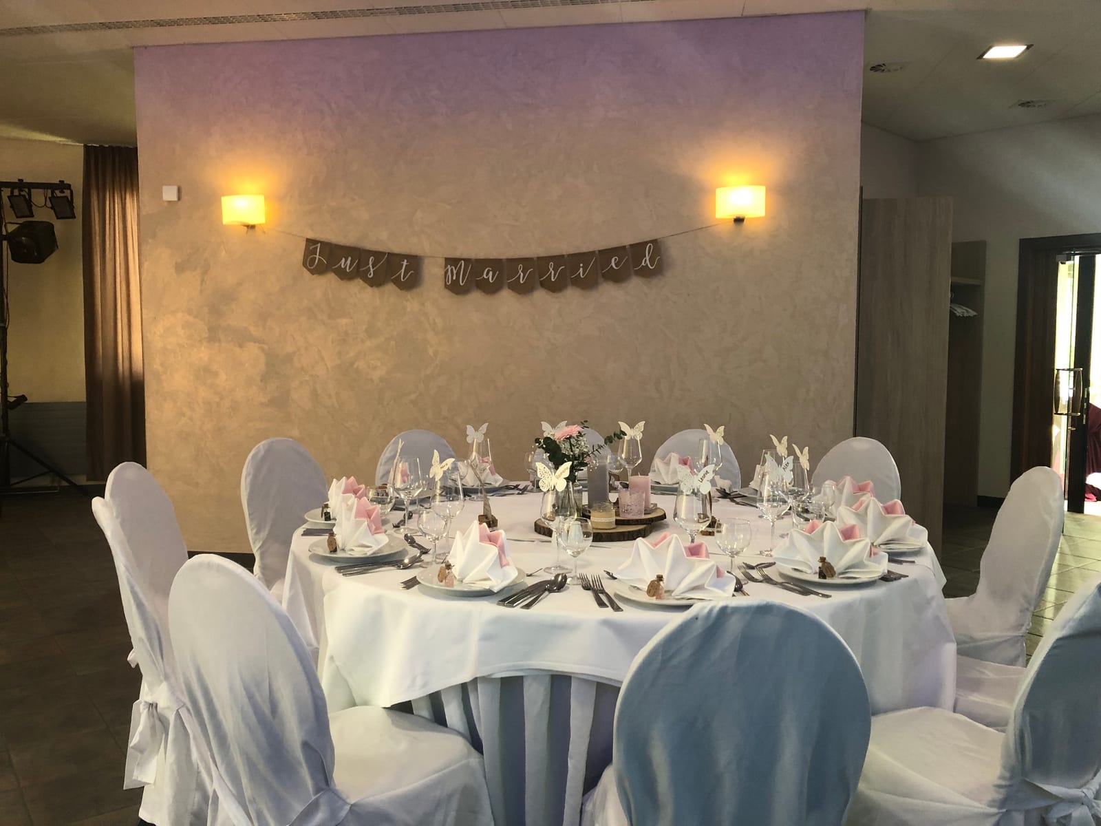 Saal mit langer Tafel und Blumendekoration